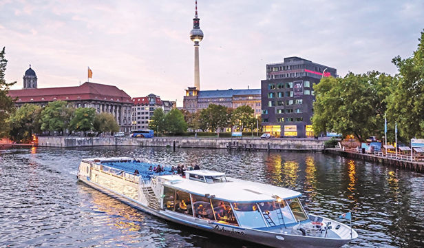Boat cruise along River Spree, passengers delighting in scenic river views and the allure of the city's captivating attractions.