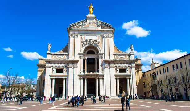 A stunning photo of Papal Basilica of Saint Mary, a beautiful church nestled in the serene landscape of Assisi, Italy.