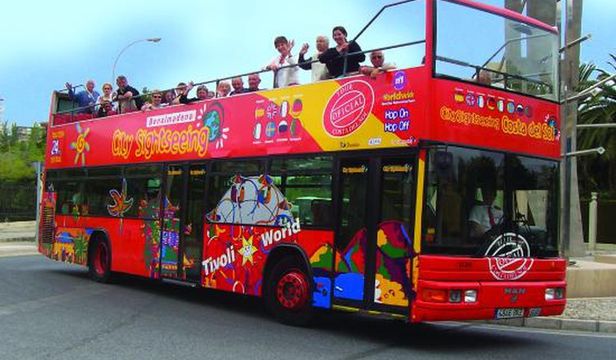 Excited tourists exploring Benalmadena from the comfort of a Hop-on Hop-off bus, enjoying the sights and attractions of the city.