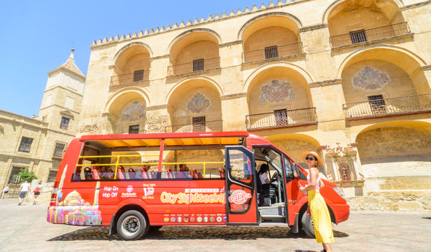 Young traveler eagerly boarding the City Sightseeing Cordoba Hop-On, Hop-Off bus, full of anticipation for city exploration.
