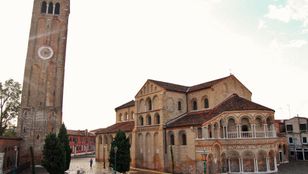 Daytime view of the stunning Church of San Donato in Venice, a beautiful architectural marvel against the bright sky.