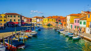 Vibrant top view of Burano and Murano Islands, colorful boats line the canals, creating a picturesque scene of vibrant hues.