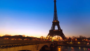 A captivating view of Paris's iconic Eiffel Tower adorned with mesmerizing lights, radiating timeless beauty and enchantment.