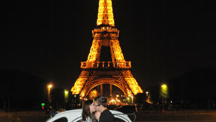 Romantic moment: Couple kissing in front of the Louvre Museum, Paris, with a cute Open Top 2CV coupe in the background.