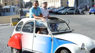 Adventures in Montmartre: Tourists strike a pose with a classic 2CV, immersing in Parisian charm and joie de vivre.