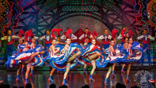 A stunning photograph that depicts a vibrant scene of the Cabaret show at Moulin Rouge Paris, the ambience is alive with energy and excitement.