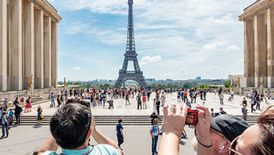 A charming shot: a child, on a Toot bus in Paris, snapping captivating pictures of the iconic Eiffel Tower through their camera lens.