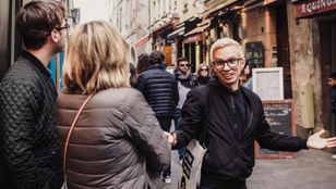 Adventurous tourists strolling Parisian streets, engaged in lively conversations, soaking in the city's enchanting ambiance.