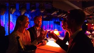 Couples delightfully raise their glasses, savoring unforgettable moments and pure joy together inside the iconic Moulin Rouge.