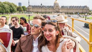 Joyful couple capturing the serenity of Paris on a Tootbus, savoring the tranquil empty streets, creating memories with a picture-perfect pose.
