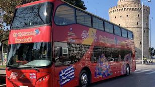 Bright red City Sightseeing Thessaloniki Hop-On, Hop-Off bus gracefully glides through the streets, revealing the beauty of Thessaloniki.