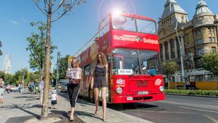 Exploring Budapest's charm with great company, as two girls wander the streets with the iconic Hop on Hop off bus adding to the ambiance.