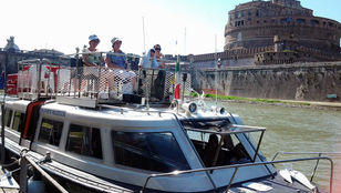 Passengers embark on a memorable journey aboard a Rome Hop-on Hop-off boat, sailing through the city's vibrant river.