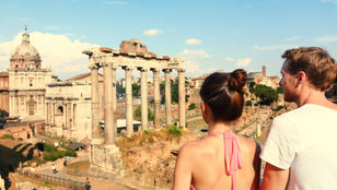 Captivating moment: A couple gazes in awe at the majestic Colosseum, immersed in admiration for its timeless beauty.