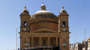 Enthusiastic passengers on a Hop-on Hop-off bus marveling at Malta's stunning architecture, capturing memorable moments.