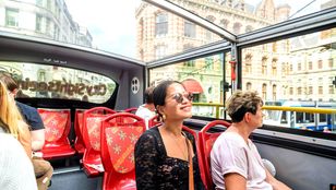 Passengers delight in their Amsterdam city sightseeing experience as they enjoy the vibrant atmosphere from the comfort of the bus.