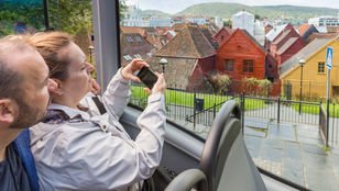 Joyful passengers capturing memories on City Sightseeing Hop-On, Hop-Off Bus, cherishing the beauty of the surroundings through their lenses.