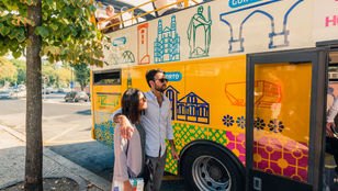 Excited couple eagerly boarding the Yellow Bus Lisbon, ready to embark on a delightful journey through the vibrant city.