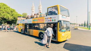 A happy couple hopping on the Lisbon Hop-on Hop-off bus, ready to explore the city's attractions and create lasting memories together.