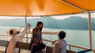 Romantic couple embracing the beauty of Lisbon on a delightful Hop-on Hop-off Boat tour, creating cherished memories together.