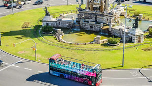 Aerial view of Barcelona city with vibrant bus weaving through Gaudi's famous architectural wonders: A colorful urban tapestry.