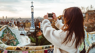 Enthusiastic young girl capturing Gaudi's architectural beauty: Preserving timeless masterpieces through her lens.