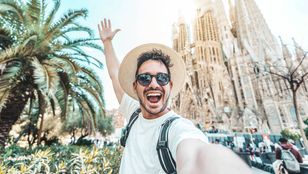 Excited boy posing with iconic Sagrada Familia by Gaudi: A moment of joy and admiration amidst architectural marvels.