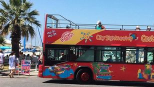 Adventurous tourists disembarking the City Sightseeing Hop-On, Hop-Off bus, ready to discover the mesmerizing sea life of Benalmadena.