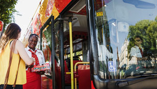 Friendly bus hosts warmly greeting passengers aboard the City Sightseeing Seville Hop-On Hop-Off bus, creating a welcoming atmosphere.