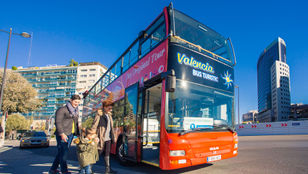 A joyful family embarking on the Valencia Turistic Hop-On, Hop-Off bus, ready for an exciting city exploration together.