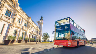 Empty Hop-On, Hop-Off bus awaits passengers by the famous Valencia attraction, ready for an unforgettable sightseeing experience.