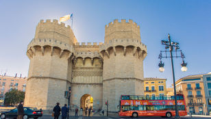 Hop-On, Hop-Off bus patiently awaits passengers at renowned Valencia attraction, ready to embark on a memorable adventure.