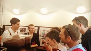 Savoring welcome drinks at a Melbourne cafe, tourists bond over laughter and joy, creating cherished memories together.