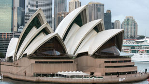 Stunning close-up captures Sydney Harbour cruise, glistening waters, iconic landmarks, and a picturesque sky-painted backdrop.