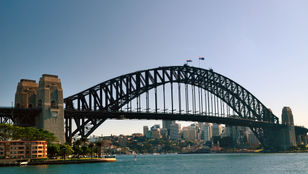 A stunning picture showcasing Sydney's iconic bridge against the backdrop of the city's captivating skyline creates a breathtaking urban vista.