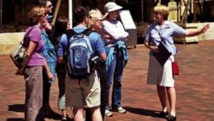 Enthusiastic tourists joyfully engage in Sydney's original Rocks tour, captivated by the history and charm of the area.